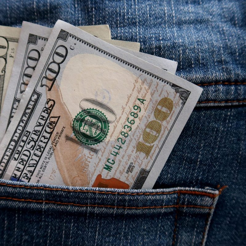 pieniądze w kieszeni symbolizujące jak najlepsza książka motywacyjna pomaga pokonać brak motywacji do pracy